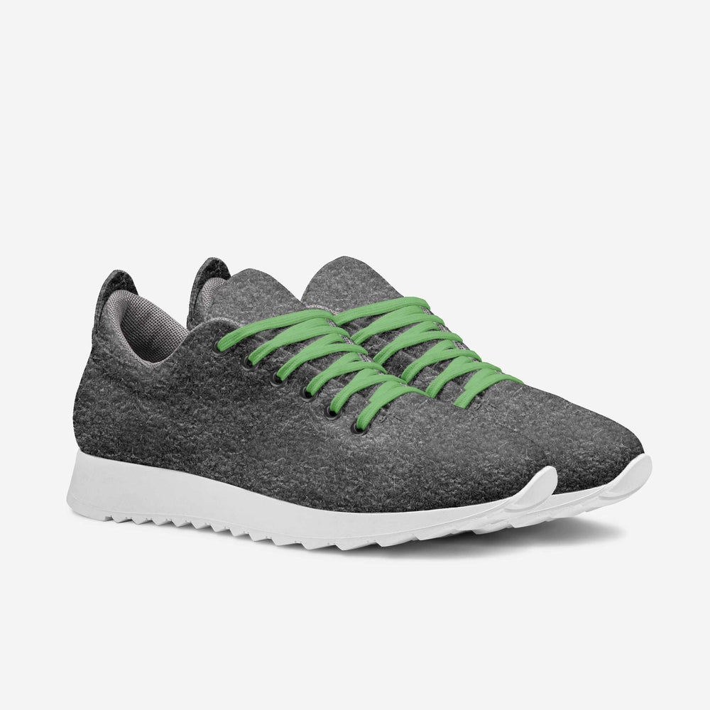 Eco-friendly, vegan 'Align' sneakers with a gray textured upper and green laces, paired with sweatpants, showcasing sustainable luxury.