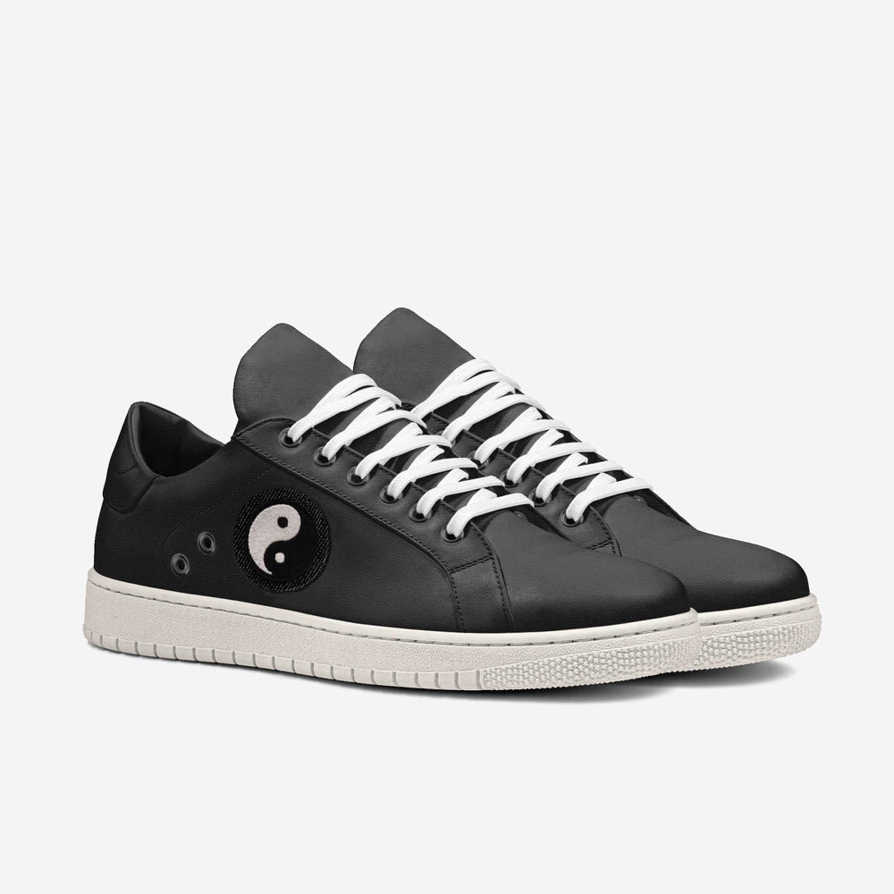 Vegan 'Gravity' sneakers in sleek low-top black, featuring a Yin-Yang patch on the side, blending eco-conscious materials with symbolic design.