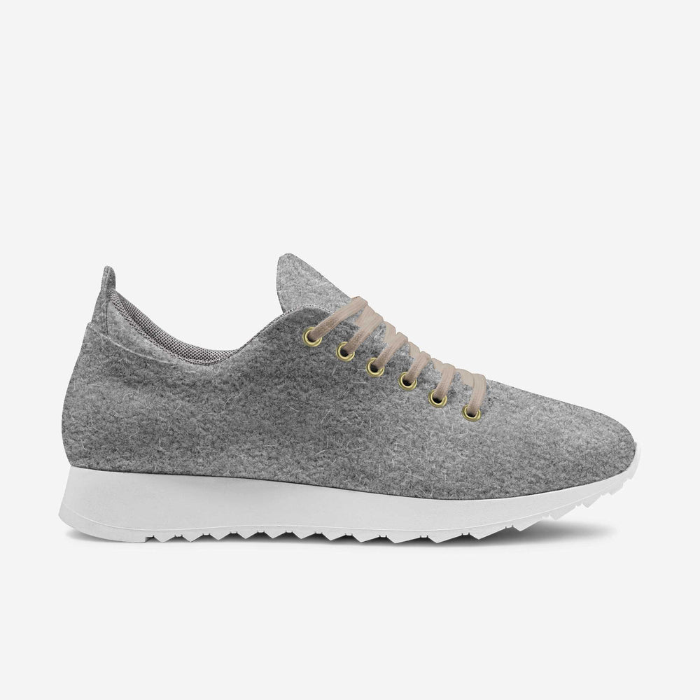 Soft grey wool low-top sneakers with white soles and comfortable texture, matched with rolled-up brown trousers.