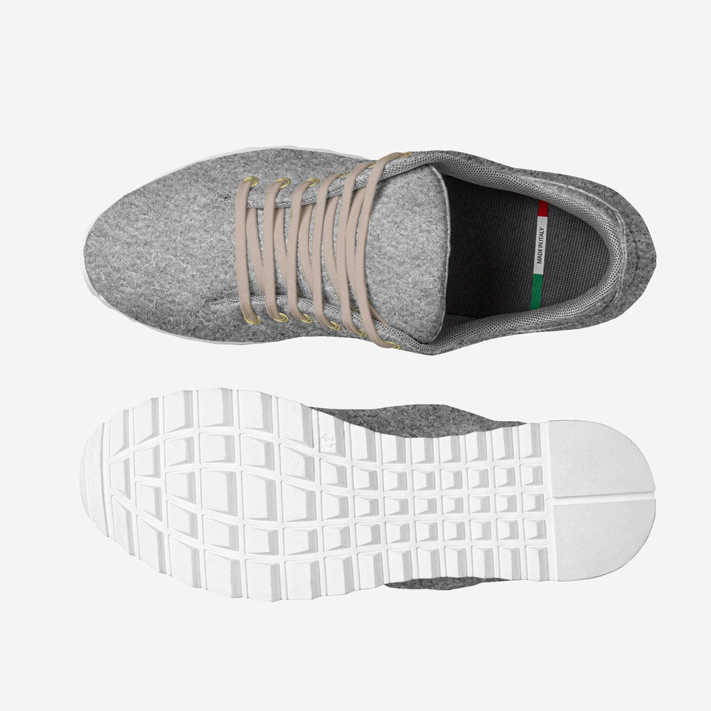 Soft grey wool low-top sneakers with white soles and comfortable texture, matched with rolled-up brown trousers.