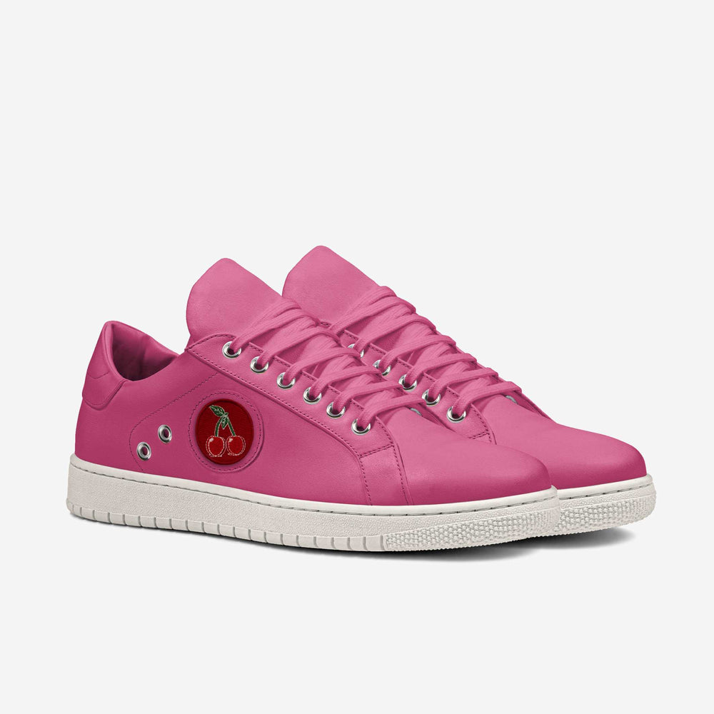 Vibrant pink sneakers with embroidered cherries emblem, paired with floral trousers for a bold, sustainable look.